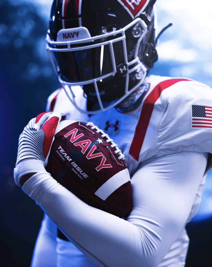 Image of Navy football player in uniform holding football